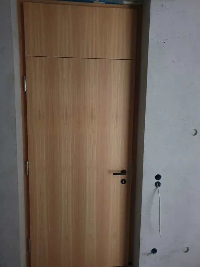 Geschlossene Holztür mit schwarzem Griff