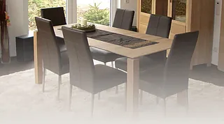 Esszimmer mit rechteckigem Holztisch und sechs gepolsterten Stühlen, Tisch mit dunkelgrauem Läufer und Kerze in Glasbehälter.